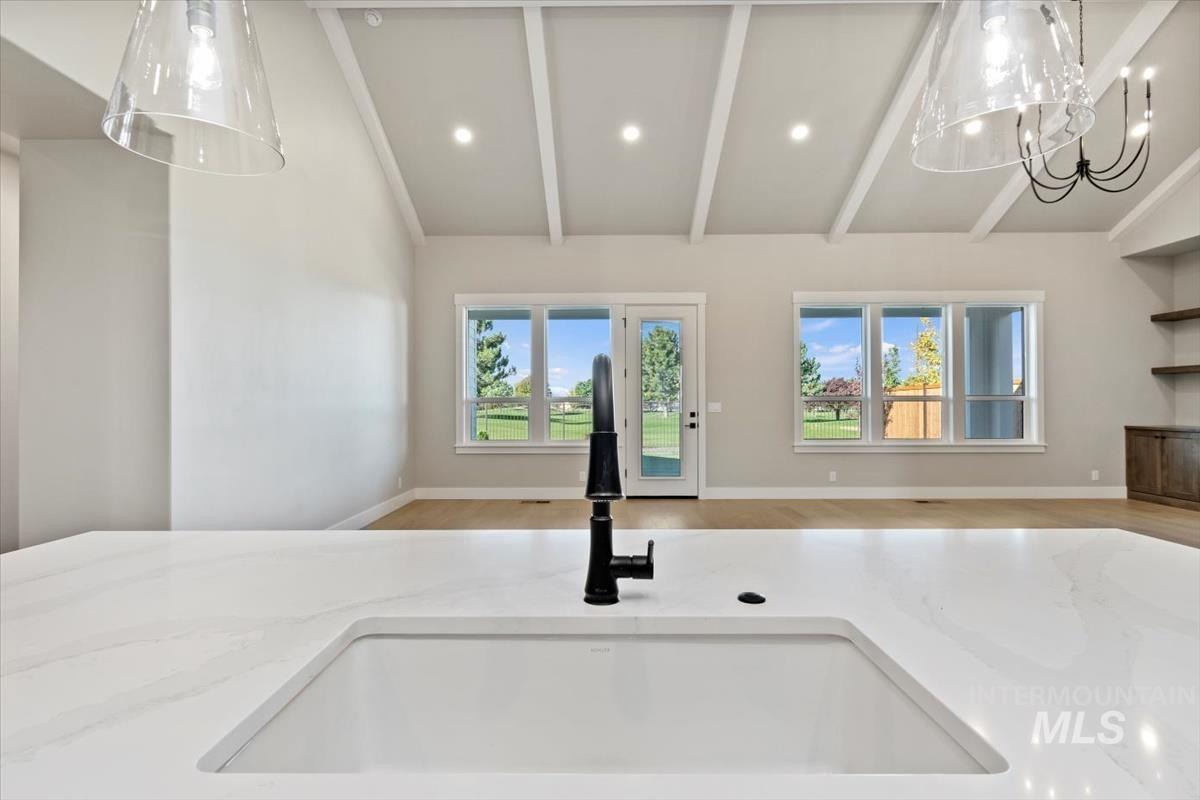 7353 Powell Place Eagle, ID 83714 - Photo 19 of 45 Kitchen view of hanging light fixtures, light stone counters, recessed lighting, and a chandelier