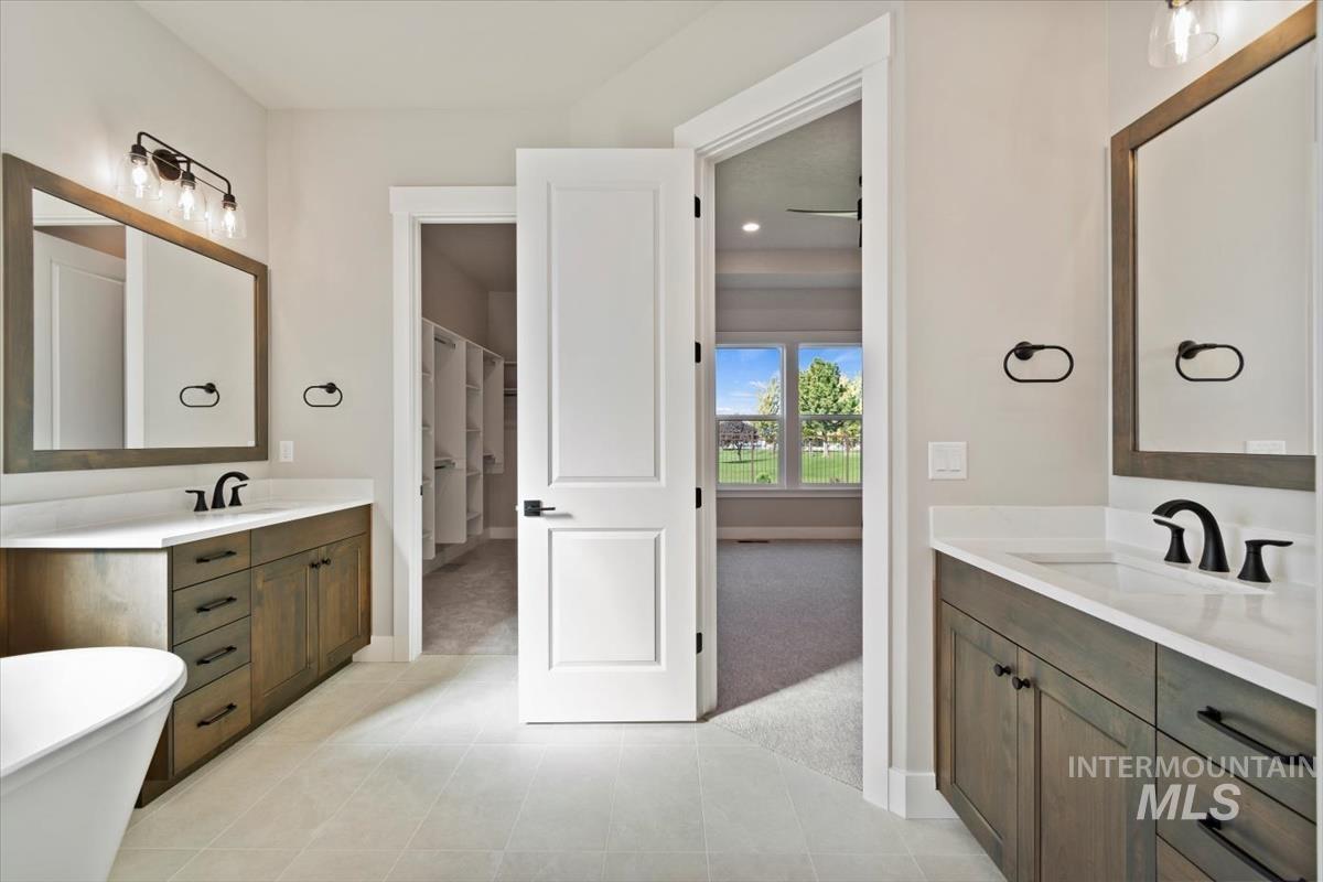 7353 Powell Place Eagle, ID 83714 - Photo 26 of 46 Full bath featuring vanity, light colored carpet, a soaking tub, and light tile patterned flooring