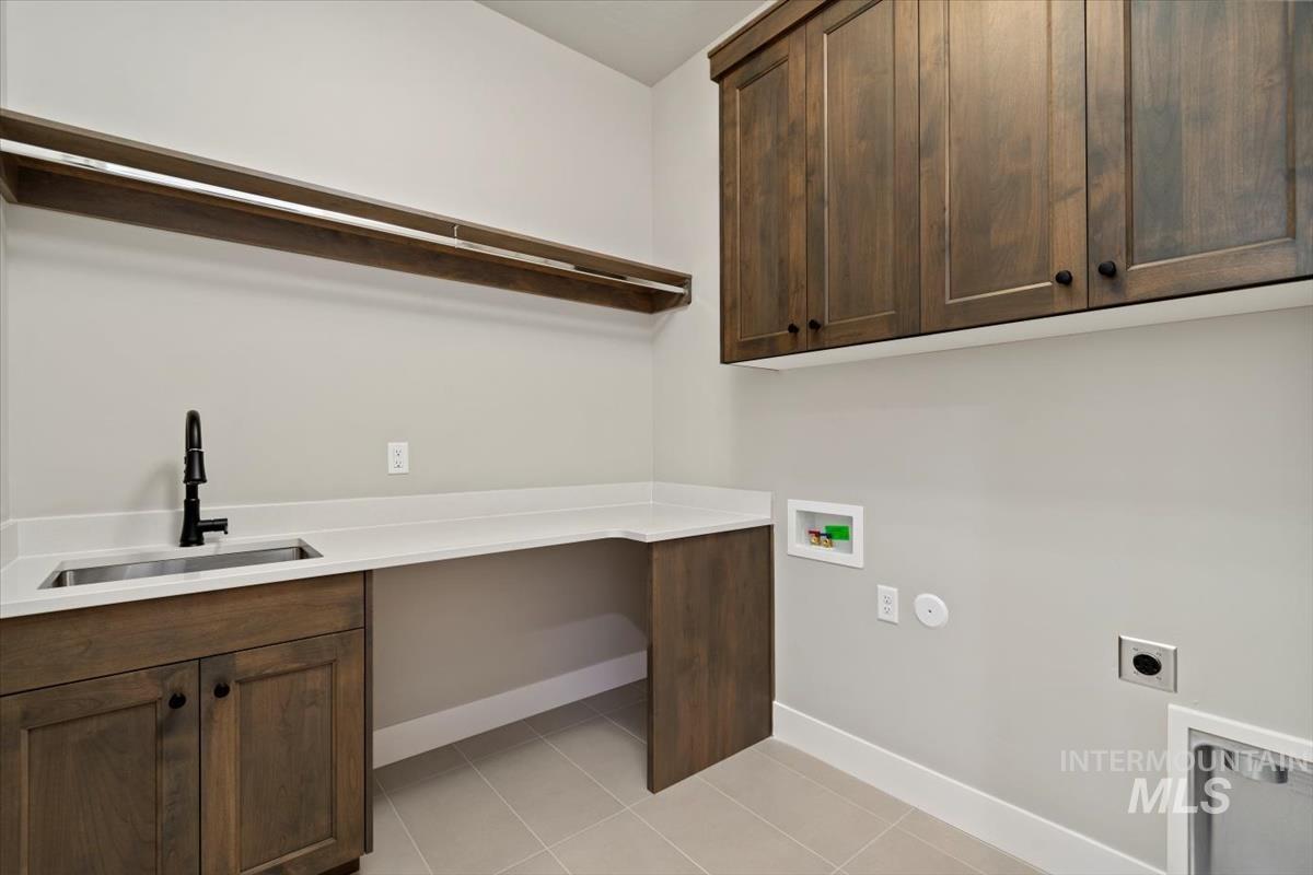 7353 Powell Place Eagle, ID 83714 - Photo 37 of 45 Laundry area featuring washer hookup, electric dryer hookup, light tile patterned floors, and cabinet space