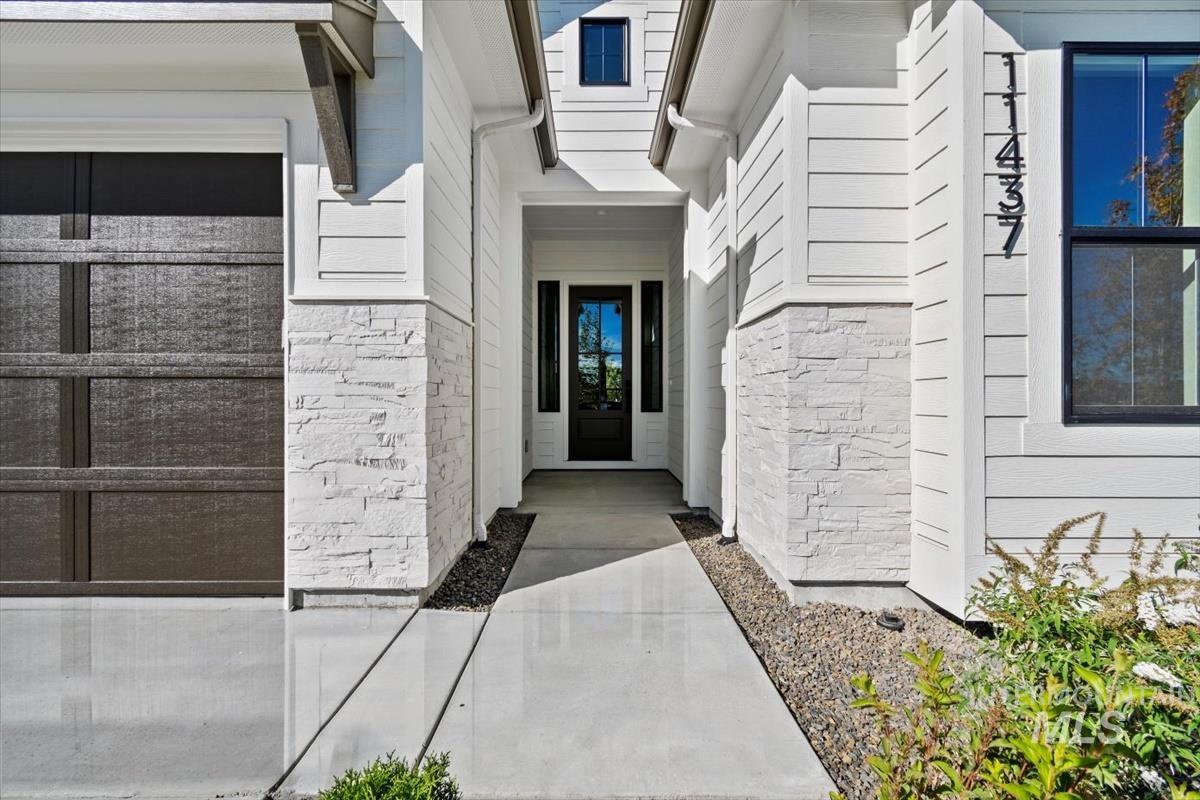 7353 Powell Place Eagle, ID 83714 - Photo 4 of 45 Entrance to property with stone siding and a garage