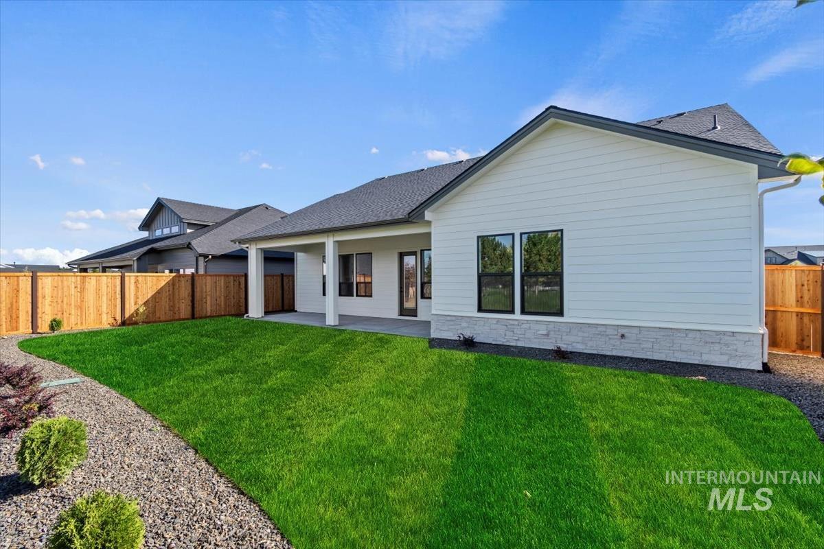 7353 Powell Place Eagle, ID 83714 - Photo 43 of 45 Back of house with a patio, roof with shingles, a fenced backyard, and stone siding