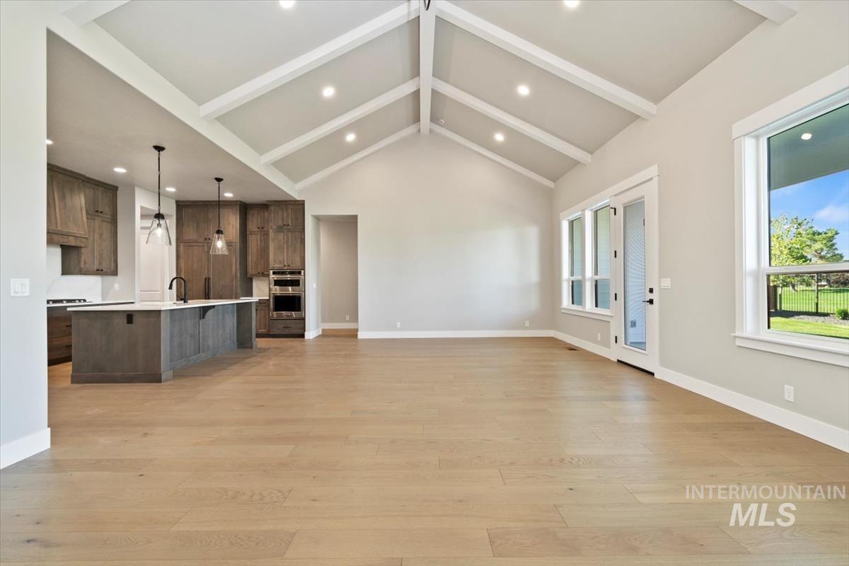 7353 Powell Place Eagle, ID 83714 - Photo 9 of 45 Unfurnished living room featuring recessed lighting, beam ceiling, light wood finished floors, and high vaulted ceiling