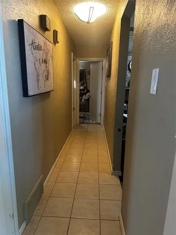 a hallway with painting on the wall and a large mirror