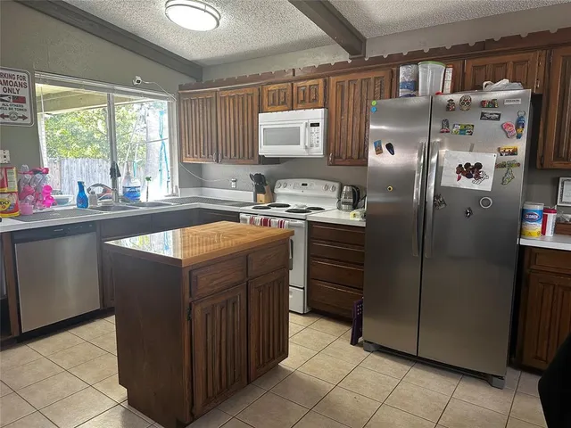 a kitchen with a sink window and refrigerator