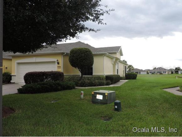 9587 Southwest 70th Loop Ocala, FL 34481 - Photo 1 of 1 a front view of a house with garden