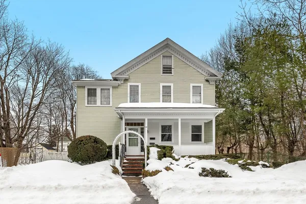 a front view of a house with a yard covered in snow