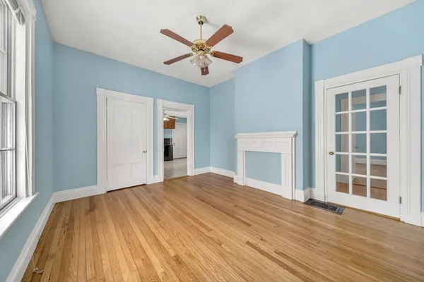 a view of a livingroom with wooden floor and a ceiling fan