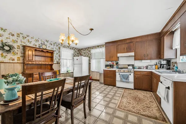 a kitchen with a table chairs microwave and cabinets