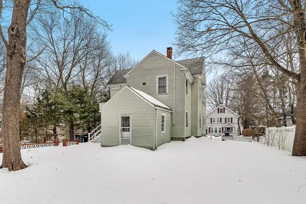 a view of a house with a yard covered in snow
