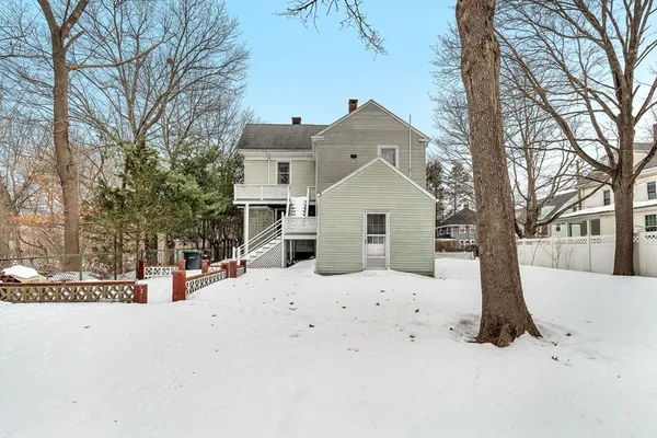 a view of white house with a yard covered in snow