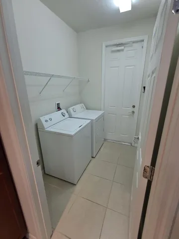 a kitchen with kitchen island granite countertop a sink and a refrigerator