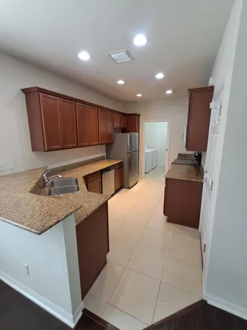 a view of a sink a refrigerator and window