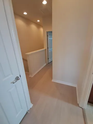 an empty room with windows and chandelier fan