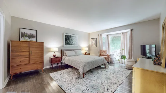 a bedroom with a bed and large windows