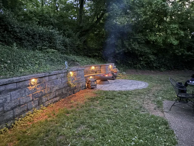 a backyard of a house with table and chairs under an umbrella
