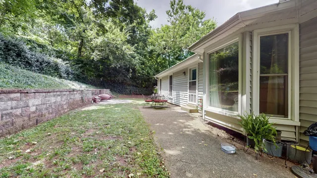 a view of a chair and table in backyard of the house
