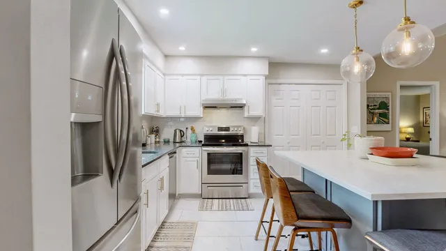 a kitchen with stainless steel appliances granite countertop a sink refrigerator and cabinets