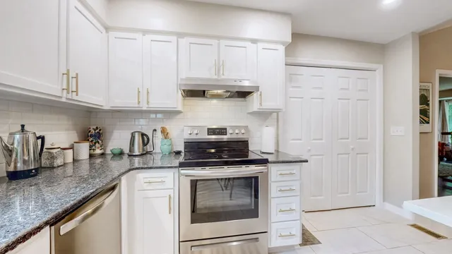 a kitchen with granite countertop a stove sink and cabinets