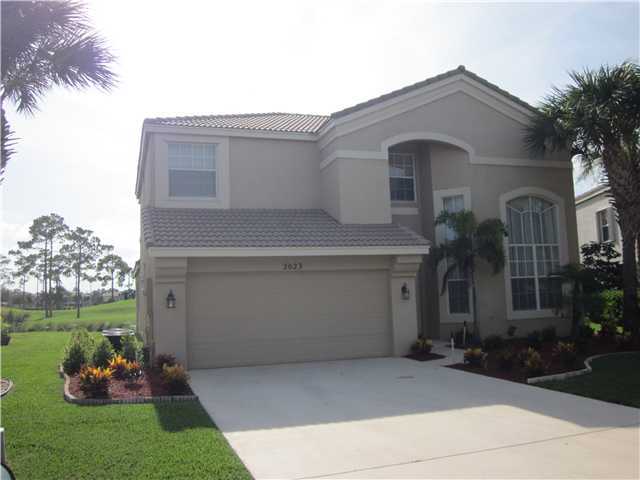 2023 Reston Circle Royal Palm Beach, FL 33411 - Photo 3 of 23 a front view of a house with a garden and plants
