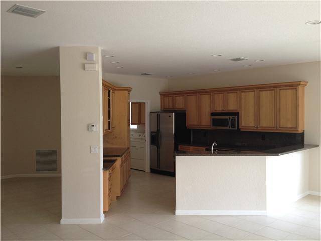 2023 Reston Circle Royal Palm Beach, FL 33411 - Photo 7 of 23 a kitchen with stainless steel appliances a refrigerator and a stove top oven