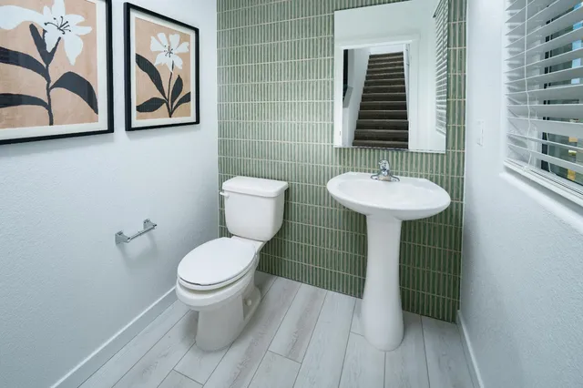 a bathroom with a toilet sink and mirror