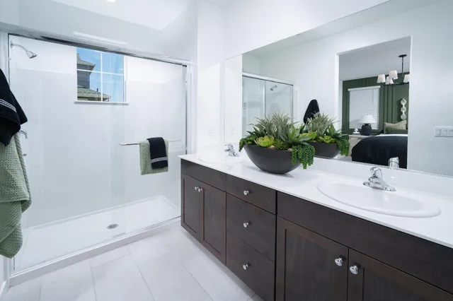 a bathroom with a double vanity sink mirror and shower