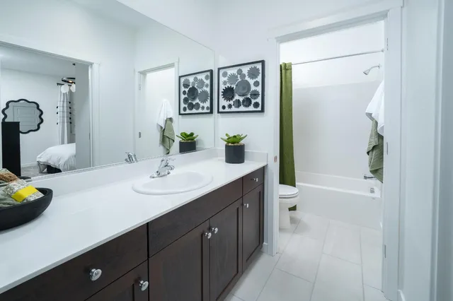 a bathroom with a double vanity sink toilet and shower