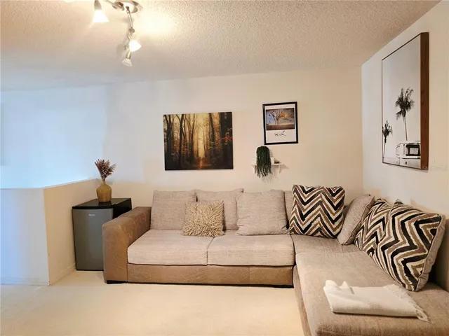 a living room with furniture and painting on the wall