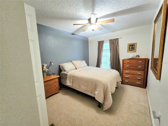 a bedroom with a bed dresser and a chandelier