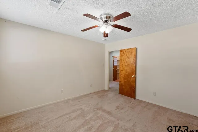 an empty room with closet and fan
