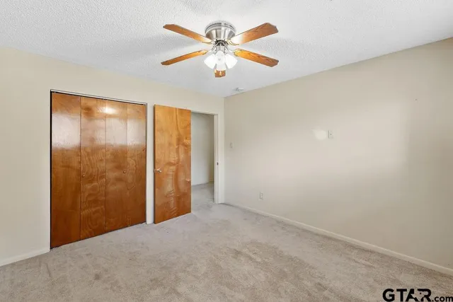 an empty room with chandelier fan