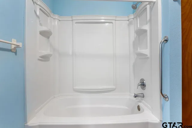 a bathroom with a shower and a bath tub