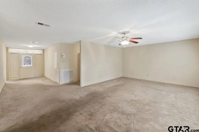 an empty room with fan and ceiling fan
