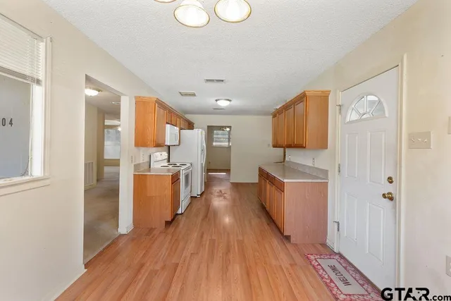 a kitchen with sink a refrigerator and wooden floor