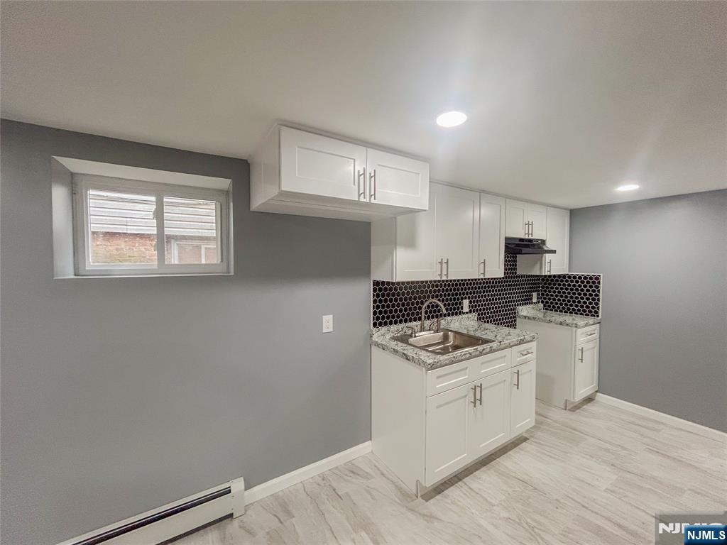 676 South 20th Street Newark, NJ 07103 - Photo 31 of 38 a kitchen with a stove a sink and a microwave
