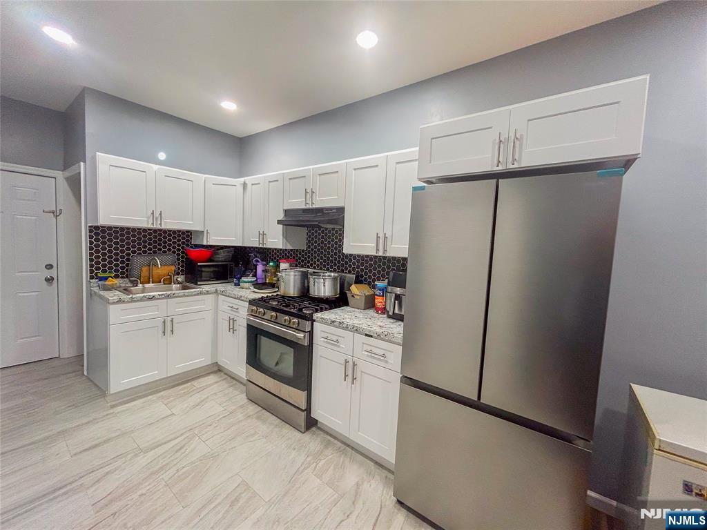 676 South 20th Street Newark, NJ 07103 - Photo 6 of 38 a kitchen with white cabinets and white appliances