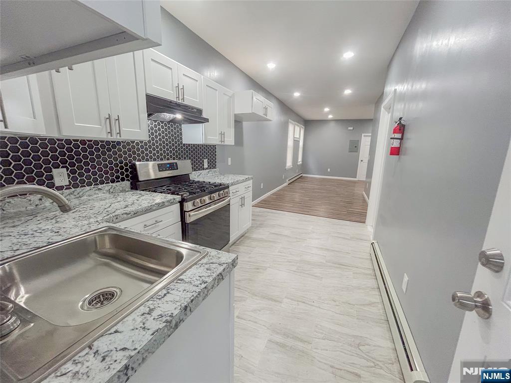 676 South 20th Street Newark, NJ 07103 - Photo 8 of 38 a kitchen with stainless steel appliances granite countertop a sink and a stove