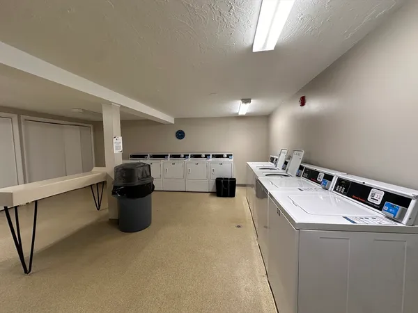 a living room with stainless steel appliances kitchen island a sink a stove and white cabinets