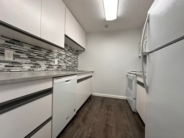 a view of a kitchen with wooden floor and electronic appliances