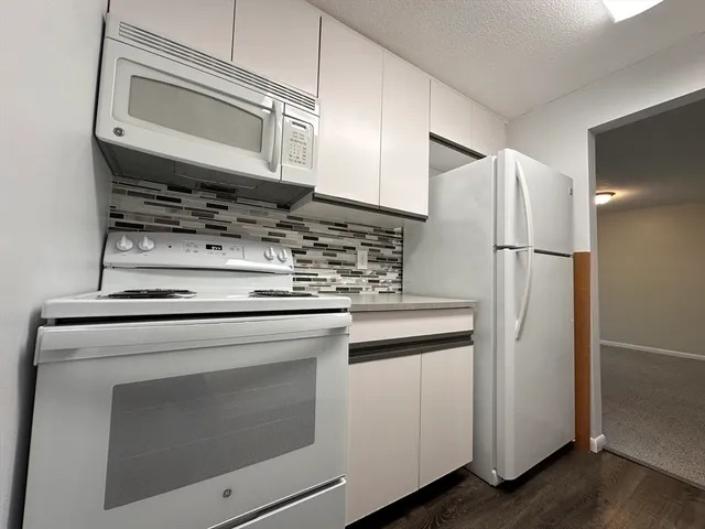 a kitchen with stainless steel appliances white cabinets and a refrigerator