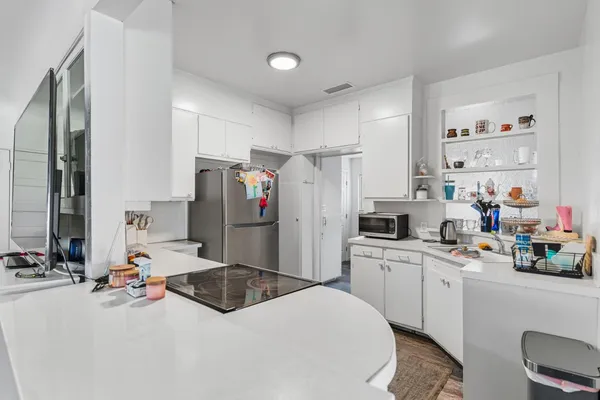 a kitchen with a sink refrigerator and cabinets