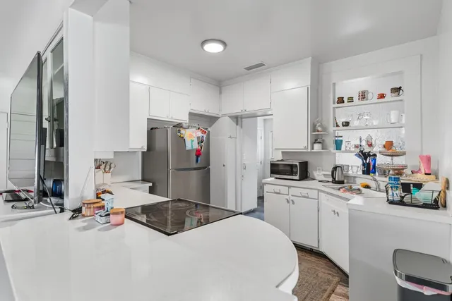 a kitchen with a sink refrigerator and cabinets