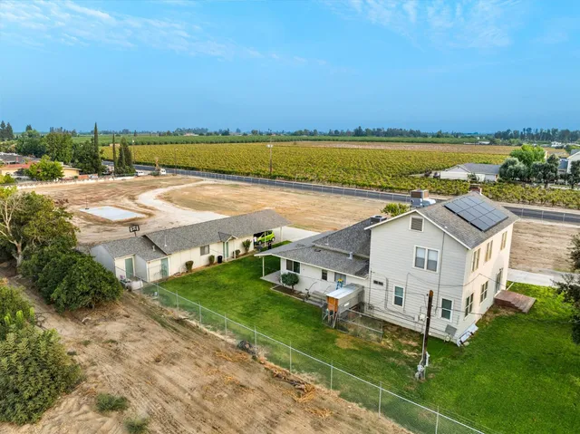 an aerial view of residential houses with outdoor space and ocean