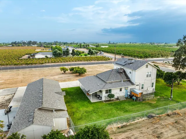 an aerial view of a house with a yard and lake view