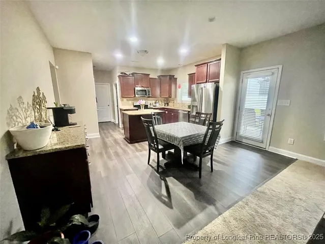 a view of a hallway with dining area and chandelier