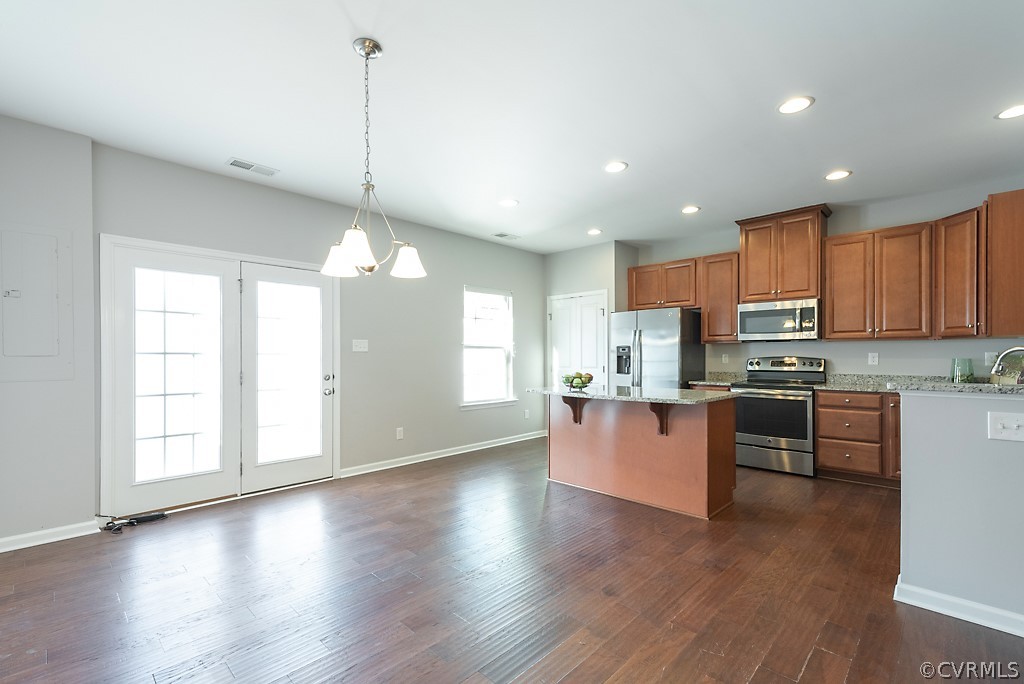 5613 Riverside Heights Way Richmond, VA 23225 - Photo 12 of 41 a kitchen with stainless steel appliances granite countertop wooden floors wooden cabinets a window and a sink