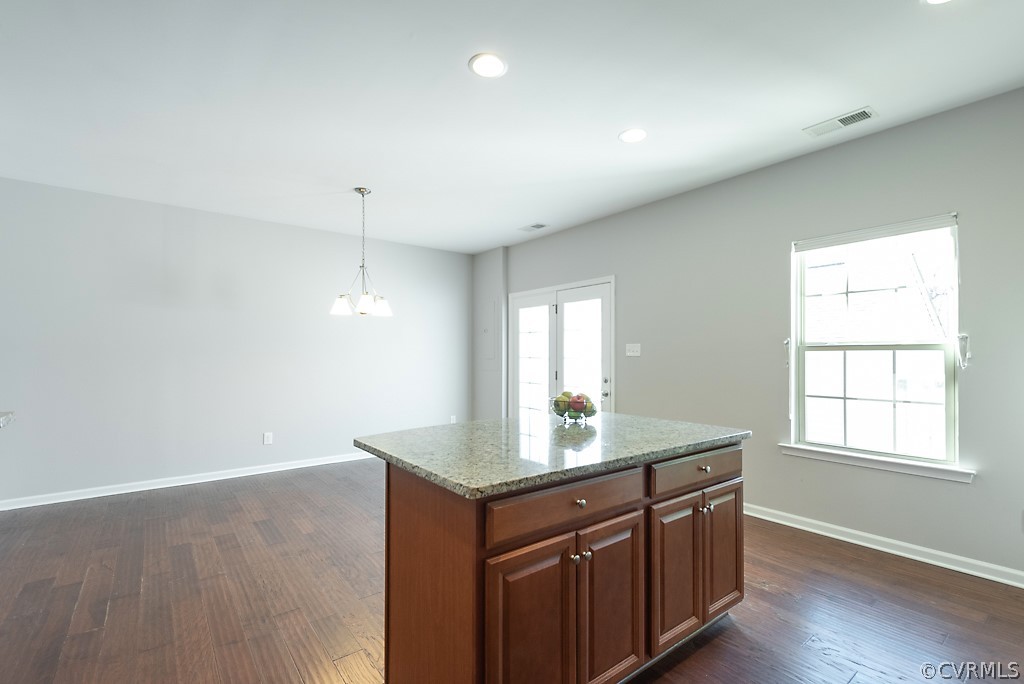 5613 Riverside Heights Way Richmond, VA 23225 - Photo 14 of 41 a room with kitchen island granite countertop wooden cabinets and white appliances