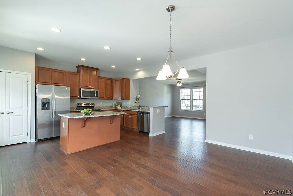 5613 Riverside Heights Way Richmond, VA 23225 - Photo 15 of 41 a kitchen with stainless steel appliances kitchen island granite countertop a refrigerator a sink dishwasher a stove and a wooden floor