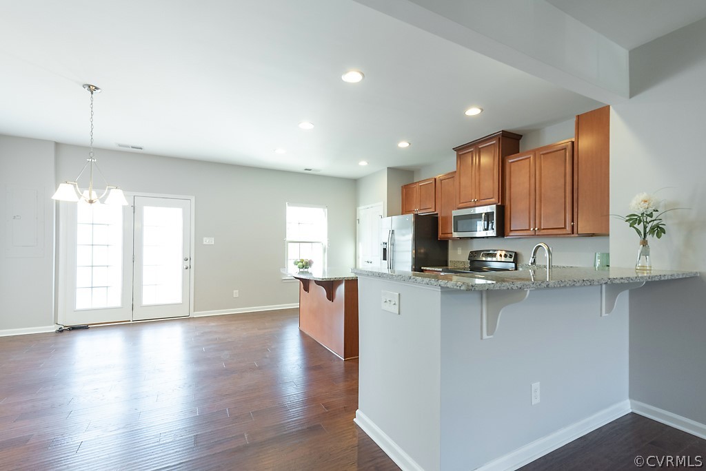 5613 Riverside Heights Way Richmond, VA 23225 - Photo 8 of 41 a kitchen with stainless steel appliances granite countertop a sink a stove top oven a counter space and cabinets