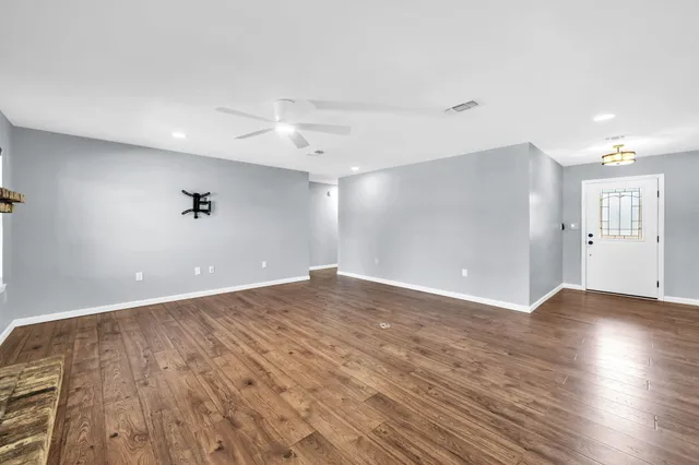 a view of an empty room with wooden floor